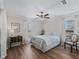 Bedroom featuring a bed, wooden floor, a chair, and two windows with natural light at 1804 Estafana Way, The Villages, FL 32159