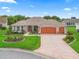 Charming single-story home with a three-car garage, manicured lawn, and colorful landscaping at 1804 Estafana Way, The Villages, FL 32159
