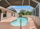 Inviting screened-in pool with patio, and lush backyard area at 1804 Estafana Way, The Villages, FL 32159