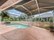 Screened-in pool and patio area, surrounded by lush landscaping at 1804 Estafana Way, The Villages, FL 32159