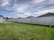 Expansive backyard featuring lush green grass and a white fence, providing a private and spacious outdoor retreat at 1914 Hux Ct, The Villages, FL 34762