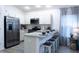 Bright kitchen features white cabinets, stainless steel appliances, and a breakfast bar with seating at 1914 Hux Ct, The Villages, FL 34762