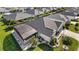 Beautiful aerial view of home featuring screen enclosed patio, manicured lawn, and mature landscaping at 1940 Dempsey Ln, The Villages, FL 32163