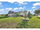 Spacious backyard with lush green grass, lovely landscaping, and a screened-in lanai, perfect for outdoor enjoyment at 1940 Dempsey Ln, The Villages, FL 32163