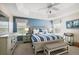 Comfortable bedroom features a tray ceiling, ceiling fan, and ample natural light at 1940 Dempsey Ln, The Villages, FL 32163