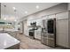 Well-lit kitchen with stainless steel refrigerator, oven, microwave, and light wood flooring at 1940 Dempsey Ln, The Villages, FL 32163
