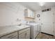 Laundry room with white cabinets, sink, countertop, and laundry machines at 1940 Dempsey Ln, The Villages, FL 32163