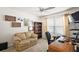 Cozy home office with love seat, bookshelf, desk, and a ceiling fan at 1940 Dempsey Ln, The Villages, FL 32163