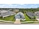 Beautiful aerial view of a single-Gathering home with lush green landscaping, a driveway, and neighboring houses at 1966 Wallingford Loop, Mount Dora, FL 32757