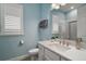 Bright bathroom with quartz counters, white cabinets, a walk-in shower, and shuttered windows at 1966 Wallingford Loop, Mount Dora, FL 32757