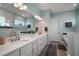 Bright bathroom with double sinks, white cabinetry, large mirror, and a separate tub and shower at 1966 Wallingford Loop, Mount Dora, FL 32757