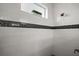Shower with white tile and black accent stripe, enhanced by a window for natural light at 1966 Wallingford Loop, Mount Dora, FL 32757