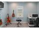 Spare bedroom showcasing guitars, a desk, and a bright window with white shutters at 1966 Wallingford Loop, Mount Dora, FL 32757