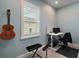 Spare bedroom showcasing guitars, a desk, and a bright window with white shutters at 1966 Wallingford Loop, Mount Dora, FL 32757