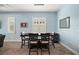 Stylish dining area with modern light fixture and view of the landscaped outdoors through shuttered windows at 1966 Wallingford Loop, Mount Dora, FL 32757