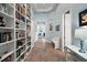 Bright hallway with hardwood floors, built-in bookshelves, and elegant decor throughout at 1966 Wallingford Loop, Mount Dora, FL 32757