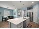 Bright kitchen with stainless appliances, large island with sink, seamlessly connecting to dining area at 1966 Wallingford Loop, Mount Dora, FL 32757