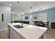 Open kitchen featuring a spacious island with sink, flowing into the living and dining areas at 1966 Wallingford Loop, Mount Dora, FL 32757