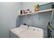 Functional laundry room with modern washer, dryer, and storage shelf for cleaning supplies at 1966 Wallingford Loop, Mount Dora, FL 32757