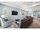 Spacious living room featuring hardwood floors, large windows, and comfortable furniture at 1966 Wallingford Loop, Mount Dora, FL 32757