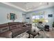 Cozy living room featuring a sectional sofa, accent chair, and sliding glass doors to the outside at 1966 Wallingford Loop, Mount Dora, FL 32757
