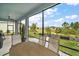 View from screened-in patio of lush backyard landscaping, with seating for outdoor dining at 1966 Wallingford Loop, Mount Dora, FL 32757