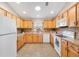 Well-lit kitchen features ample cabinet space, tiled floors, and appliances for a functional cooking area at 2042 Hydrangea Ave, The Villages, FL 32162