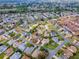 A wide aerial view of a large neighborhood with many homes, streets, and green spaces at 2103 Patino Ln, The Villages, FL 32159