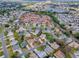 An aerial view displays a serene neighborhood with lush greenery, quiet streets, and a peaceful lake at 2103 Patino Ln, The Villages, FL 32159