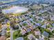 A panoramic aerial view of a neighborhood surrounding a community lake and golf course at 2103 Patino Ln, The Villages, FL 32159