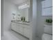 This bathroom features dual sinks with granite countertops and white cabinets at 2103 Patino Ln, The Villages, FL 32159