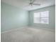 This carpeted bedroom features a ceiling fan, a large window with blinds, and neutral paint at 2103 Patino Ln, The Villages, FL 32159