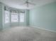 Spacious bedroom featuring neutral carpet, white walls, and multiple windows at 2103 Patino Ln, The Villages, FL 32159