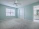 This bedroom features neutral paint, a ceiling fan, carpet, and access to the bathroom at 2103 Patino Ln, The Villages, FL 32159