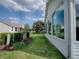 Exterior view with sunroom and manicured lawn with lush landscaping at 2103 Patino Ln, The Villages, FL 32159