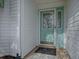 Charming aqua front door with glass window feature and black welcome mat at 2103 Patino Ln, The Villages, FL 32159