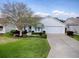 Beautiful home featuring a manicured lawn, a lush garden, and a convenient two-car garage at 2103 Patino Ln, The Villages, FL 32159