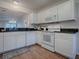 Bright kitchen featuring white appliances, granite countertops, and views of the living area at 2103 Patino Ln, The Villages, FL 32159