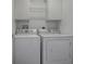Bright laundry room with white washer and dryer and matching cabinets at 2103 Patino Ln, The Villages, FL 32159