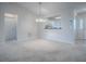 Bright living room featuring neutral carpet, white walls, and an open view into the kitchen at 2103 Patino Ln, The Villages, FL 32159