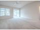 Bright, airy living room with neutral carpeting, high ceilings, and access to a sunroom at 2103 Patino Ln, The Villages, FL 32159