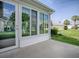 Enclosed sunroom featuring large windows, light colored siding and concrete patio at 2103 Patino Ln, The Villages, FL 32159