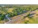 Vast aerial view showcases the property's mature trees, green pastures, and proximity to the road, all bathed in sunlight at 23519 State Road 44, Eustis, FL 32736