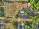 An aerial view of the property featuring a storage building, open field, and surrounding greenery at 23519 State Road 44, Eustis, FL 32736