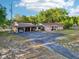 Aerial view of a charming single-story home with an extended driveway and attached carport at 23519 State Road 44, Eustis, FL 32736