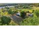 Aerial view of the property showcasing outbuildings, open fields, and surrounding trees at 23519 State Road 44, Eustis, FL 32736