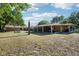 Aerial view of the property including a covered patio, golf cart, and ample fenced in yard at 23519 State Road 44, Eustis, FL 32736