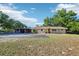 Charming single-story home featuring a large driveway, well-manicured lawn, and mature shade trees at 23519 State Road 44, Eustis, FL 32736
