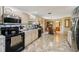 Traditional kitchen features tan tile flooring, stainless steel appliances, and views to the dining area at 23519 State Road 44, Eustis, FL 32736