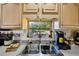 Close up of the stainless steel sink and faucet in the kitchen with decoratively adorned cabinets and window at 23519 State Road 44, Eustis, FL 32736